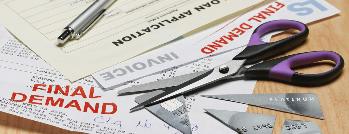 dokumenty, długopis i&nbsp;przecięta karta bankowa